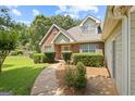 Inviting home showcasing a brick and siding facade, manicured shrubs, and a paved walkway leading to the front door at 20 Knollwood Pl, Covington, GA 30014