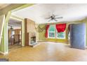 Living room featuring a brick fireplace, a ceiling fan, and views of a staircase and an adjacent room at 24 Shiloh Church Rd, Carrollton, GA 30116
