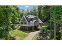 Secluded two-story home nestled among mature trees, featuring a spacious deck and a serene setting at 390 Stoneridge Way, Fayetteville, GA 30215