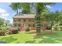 Charming brick home featuring a well-manicured lawn and vibrant green shutters at 829 Bev Ct, Lawrenceville, GA 30046