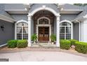 Grand entryway with stone accents, wood double doors, and manicured shrubs at 9125 Patrick Pl, Winston, GA 30187