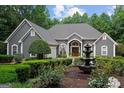 Stately gray stucco home with lush front garden and decorative fountain at 9125 Patrick Pl, Winston, GA 30187
