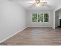 Spacious living room featuring new flooring and a view of trees outside the window at 260 Pinehurst Dr, Stockbridge, GA 30281