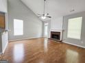 Open-concept living room with hardwood floors, fireplace, ceiling fan, and backyard access at 537 Goldfinch Way, Stockbridge, GA 30281