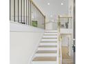 Inviting foyer features hardwood stairs and a modern metal railing with a view to the kitchen at 128 Southern Magnolia Ln, Rex, GA 30273