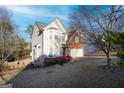 Two-story home showcasing vinyl siding, brick accents, attached garage, and mature trees at 860 Sweet Mill Ln, Lawrenceville, GA 30045