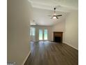 Vaulted ceilings, wood-look floors, fireplace, and French doors enhance this living space at 60 Doe Run Dr, Sharpsburg, GA 30277