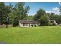 Quaint single-story home with a large grassy front yard and mature trees, set in a peaceful location at 7335 Connell Rd, Fairburn, GA 30213