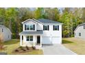Traditional two-story home with a covered front porch and a two-car garage, set in a lush green lawn at 143 Oakchase Park Ln, Hampton, GA 30228