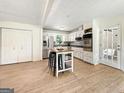 Bright kitchen with white cabinets, stainless steel appliances, and a functional island with seating at 10215 Creel Rd, Chattahoochee Hills, GA 30213