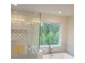 Luxurious bathroom featuring a freestanding tub, a large window, and modern fixtures at 4421 Meadowwood Dr, Loganville, GA 30052