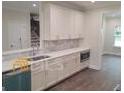 Bright kitchen featuring white cabinets, a breakfast bar, and a view into the living space at 4421 Meadowwood Dr, Loganville, GA 30052