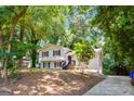 Two-story home with wood siding, complimented by mature trees, and a concrete driveway at 234 Kenilworth Cir, Stone Mountain, GA 30083