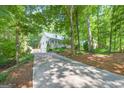 This property boasts a long driveway leading to a house nestled among mature trees at 3515 Chattahoochee Rd, Cumming, GA 30041