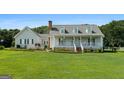 Beautiful home with a classic white porch and manicured lawn in a serene, suburban setting at 310 Trestle Rd, Locust Grove, GA 30248