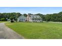 A lovely house featuring a well-maintained lawn and white picket fence that extends to the left of the property at 310 Trestle Rd, Locust Grove, GA 30248