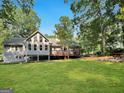 View of the back of the home with spacious deck and well-maintained backyard perfect for outdoor gatherings at 155 Little Creek Dr, Sharpsburg, GA 30277