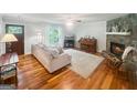 Cozy living room featuring hardwood floors, a stone fireplace, and stylish furniture at 155 Little Creek Dr, Sharpsburg, GA 30277