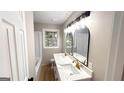 Bright bathroom featuring dual sink vanity, stone countertop, and modern lighting at 5324 Joan Of Arc, Atlanta, GA 30349