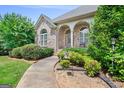 Brick home with manicured shrubbery, beautiful lawn and walkway leading to front door at 230 Hummingbird Ct, Hampton, GA 30228