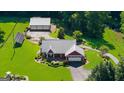 Aerial view of single-story home features a metal roof, attached garage, additional garage, manicured lawn and solar panels at 4335 Hurt Bridge Lane, Cumming, GA 30028
