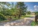 Long driveway leading to a home with a decorative gate and mature trees and landscaping at 369 Parker Rd, Mcdonough, GA 30252