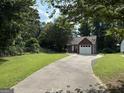 Charming home with a large yard, long driveway, brick accents, and mature trees at 8113 Fieldstream Way, Douglasville, GA 30134