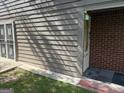 Home's side entrance with storm door, gray wood siding, and brick corner at 8113 Fieldstream Way, Douglasville, GA 30134
