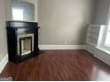 Cozy living room featuring a decorative fireplace, built-in shelves, and hardwood floors at 3155 E Point St, East Point, GA 30344