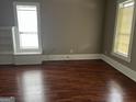 Bright living room with hardwood floors, baseboard trim, and large windows for natural light at 3155 E Point St, East Point, GA 30344