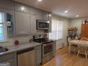 Well-lit kitchen with stainless steel appliances, gray cabinetry, and granite countertops at 439 River Rd, Jonesboro, GA 30236