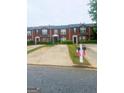 Exterior view of brick townhomes featuring well-maintained landscaping and private driveways at 5553 Strathmoor Manor Cir, Lithonia, GA 30058