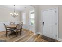 Bright dining room featuring a round table, chandelier, hardwood floors, and wainscoting at 935 S Laney Rd, Locust Grove, GA 30248