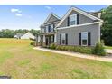 Well-maintained home with gray siding, black shutters, and a sidewalk leading to the front door at 935 S Laney Rd, Locust Grove, GA 30248
