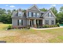 Two-story home featuring gray siding, a covered front porch, and a neatly maintained lawn at 935 S Laney Rd, Locust Grove, GA 30248