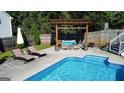 Relaxing pool area with chaise lounges, covered seating, and a fenced backyard for privacy at 401 N Lost Lake Cv, Villa Rica, GA 30180