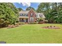 Beautiful two-story brick home with a manicured lawn, covered porch, and mature landscaping at 145 Driftwood Trl, Fayetteville, GA 30215