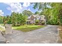 Two-story brick home with a front porch, shuttered windows, and a driveway leading to the side of the house at 145 Driftwood Trl, Fayetteville, GA 30215