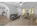 Cozy living area with a gray sofa, patterned armchairs, and natural light streaming through the bright windows at 416 River Forest Dr, Mcdonough, GA 30252