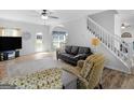 Bright living room with neutral walls, wood floors, and comfortable seating arrangement and plenty of natural light at 416 River Forest Dr, Mcdonough, GA 30252