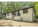 Charming single-story home featuring a blue front door, painted brick, and black trim at 3833 Bakers Ferry Sw Rd, Atlanta, GA 30331