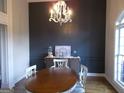 Elegant dining room featuring wainscoting, a modern chandelier, and a large window for natural light at 216 Lake Tanisha Dr, Dallas, GA 30157