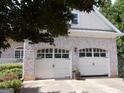 Spacious two-car garage with white doors matching the home's exterior, offering ample parking and storage space at 216 Lake Tanisha Dr, Dallas, GA 30157