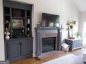 Cozy living room with a charming fireplace, built-in shelving, and a neutral color scheme for a relaxed atmosphere at 216 Lake Tanisha Dr, Dallas, GA 30157