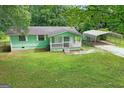 Aerial view of a quaint home with a large yard and a convenient carport at 107 Club Dr, Locust Grove, GA 30248
