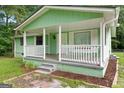 Inviting front porch featuring white railings and columns, offering a cozy outdoor space at 107 Club Dr, Locust Grove, GA 30248