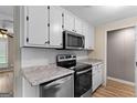 Modern kitchen featuring stainless steel appliances, granite countertops, and white cabinets at 107 Club Dr, Locust Grove, GA 30248