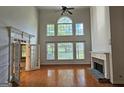 Bright living room with a cozy fireplace, large windows, hardwood floors, and an open layout at 7235 Thoreau Cir, Atlanta, GA 30349