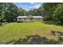 Traditional home with a well-manicured lawn, mature trees, and inviting front porch at 147 Pine St, Covington, GA 30014