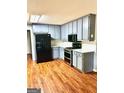 This kitchen features stainless steel appliances, light gray cabinets and wood flooring at 398 Mckenzie Dr, Stockbridge, GA 30281